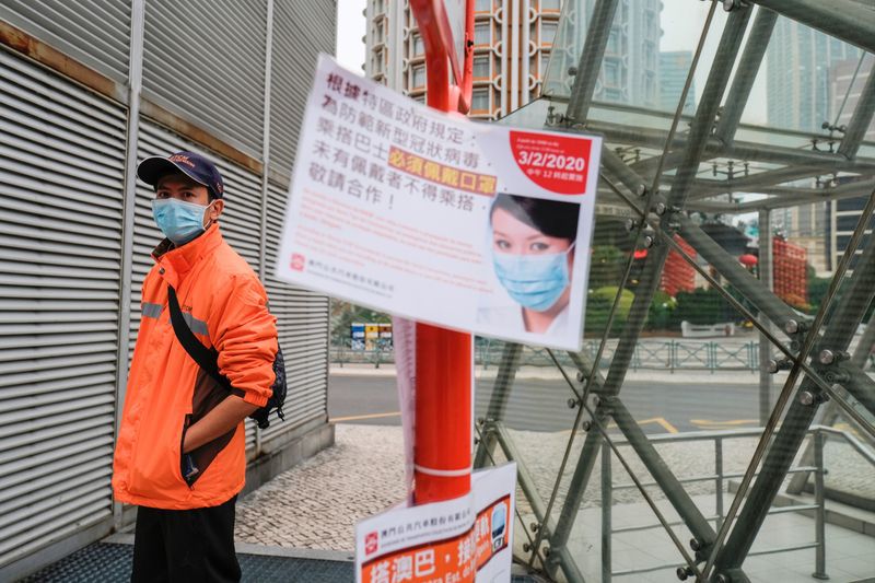 A man wears a mask as he waits for a bus, following the coronavirus outbreak in Macau, China February 5, 2020. REUTERS/Tyrone Siu