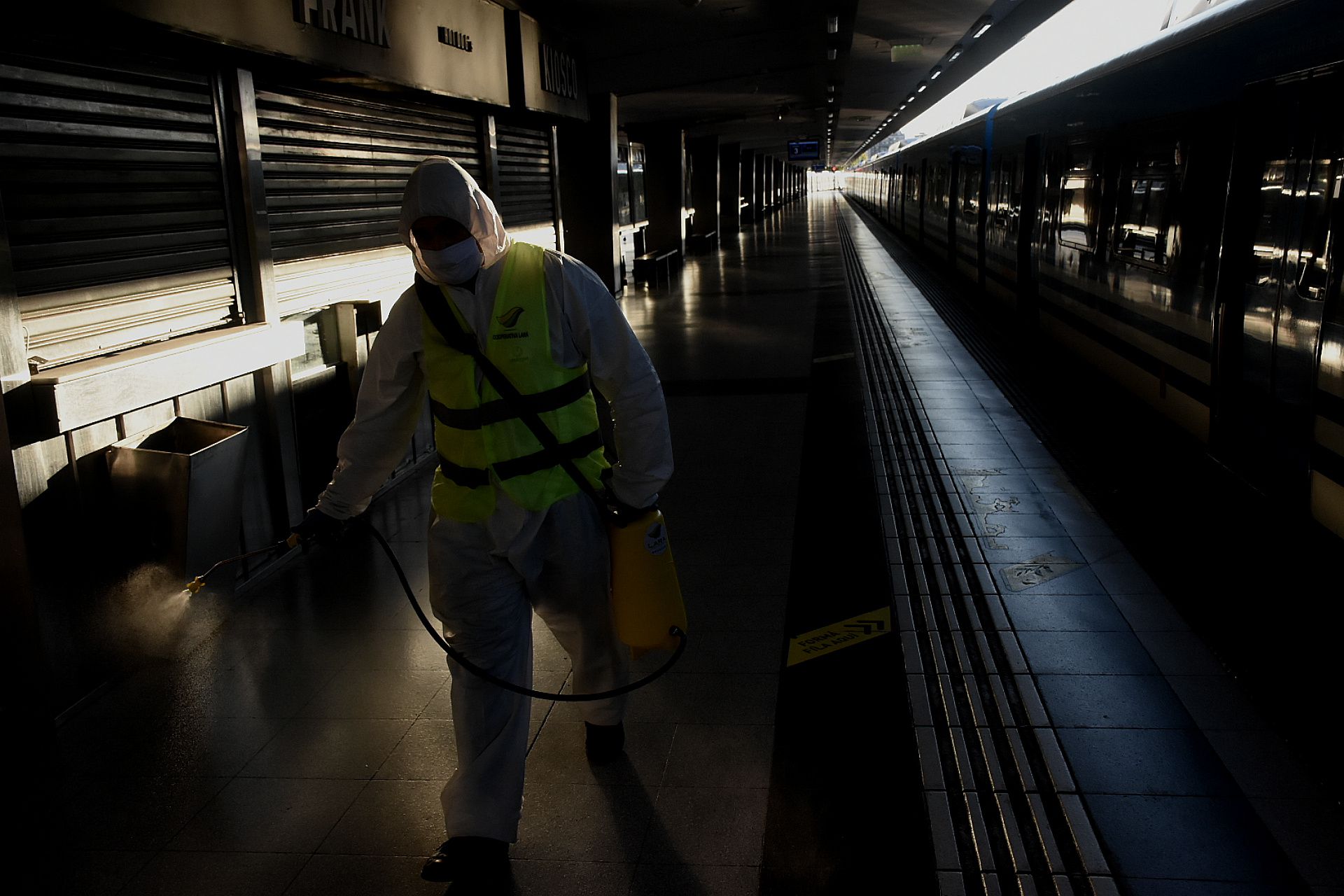 15 de abril: muy poca gente en la estación Once y un empleado porteño desinfecta los andenes