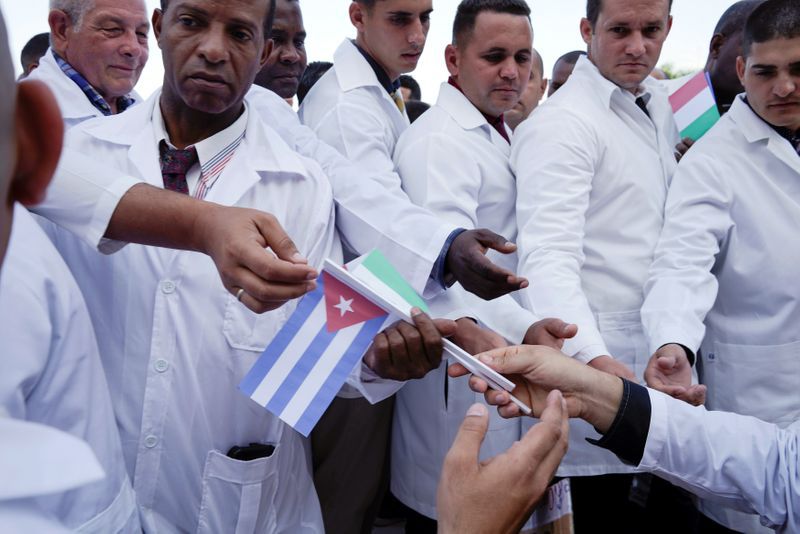 Médicos cubanos reciben banderas cubanas e italianas durante una ceremonia de despedida antes de partir a Italia para ayudar con la propagación del brote de la enfermedad por coronavirus 