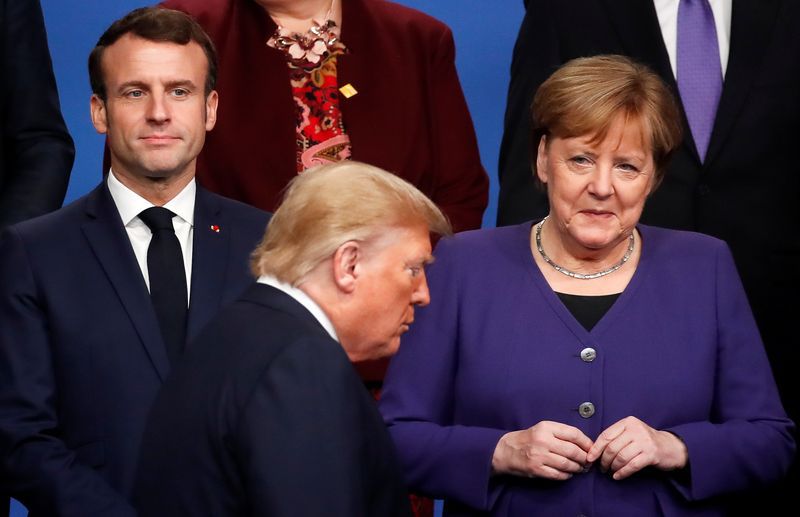 El presidente estadounidense, Donald Trump, pasa frente a su homólogo francés, Emmanuel Macron, junto a la Canciller alemana, Angela Merkel (Reuters)