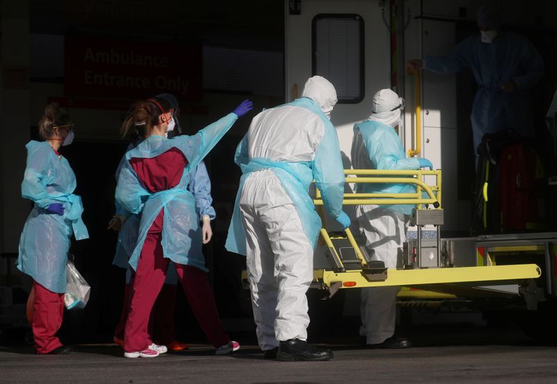 Personal médico con ropa de protección saca a un paciente de una ambulancia en el hospital de St Thomas, mientras continúa la propagación del coronavirus, en Londres, Reino Unido, 31 de marzo de 2020. REUTERS/Hannah McKay