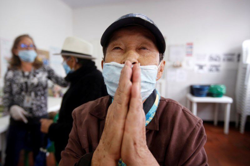 Una anciana usa un tapabocas hace gestos dentro de un comedor durante el aislamiento del coronavirus 
