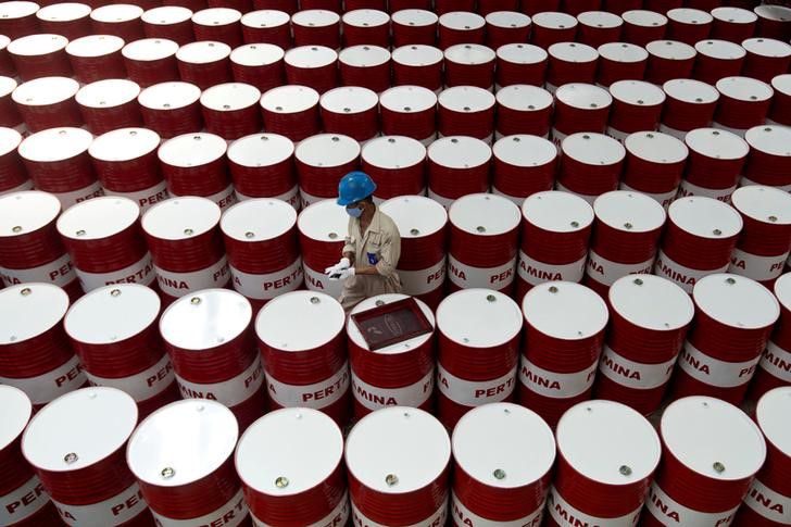 Un trabajador etiqueta barriles de petróleo (REUTERS)