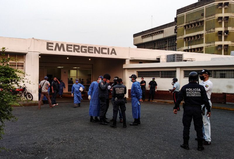 Trabajadores de la salud y miembros de la Policía Nacional Bolivariana esperan la llegada de los prisioneros fuera de un hospital después de que estallara un motín dentro de una prisión en Guanare, Venezuela, el 1 de mayo de 2020. REUTERS/Manuel Alvarado