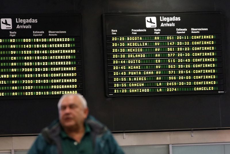 Foto de archivo. Un pasajero pasa frente a un tablero con anuncios de vuelos en el aeropuerto Jorge Chávez de Callao, en Perú. 16 de agosto de 2018. REUTERS/Mariana Bazo
