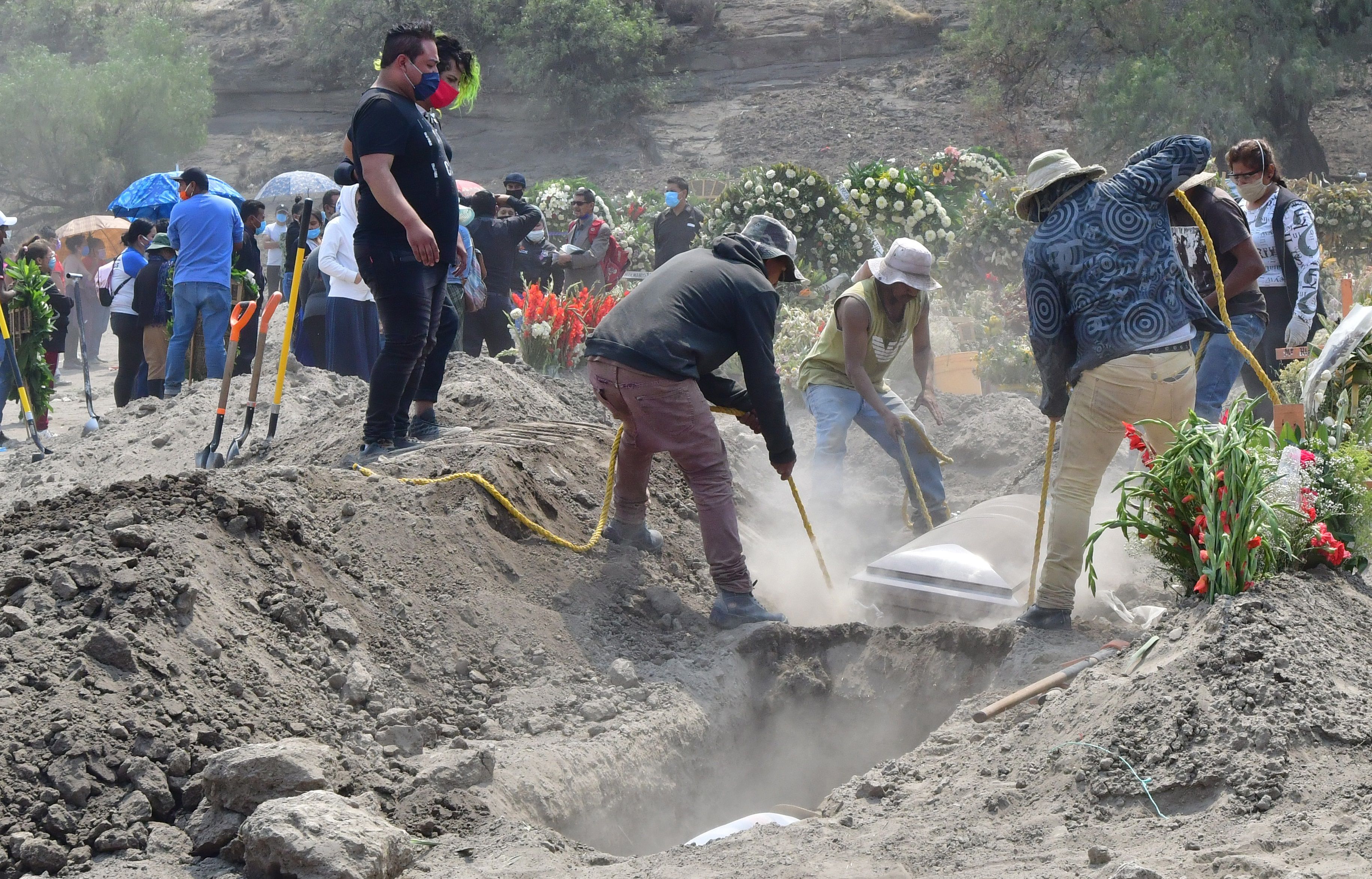 Fotografía fechada el 28 de Mayo de 2020 que muestra a trabajadores municipales mientras realizan entierros, en el terregoso panteón del municipio de Valle de Chalco (México). EFE/Jorge Núñez