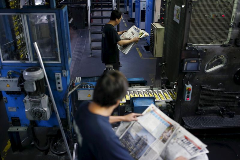 FOTO DE ARCHIVO: Operadores de prensa inspeccionan la calidad de impresión del periódico Apple Daily, publicado por la imprenta de Next Media Ltd en Hong Kong, China, el 26 de noviembre de 2015. REUTERS/Tyrone Siu