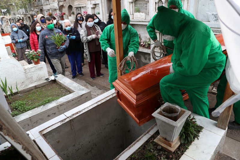 Trabajadores del cementerio entierran el ataúd de José, de 68 años, que murió de la enfermedad del coronavirus (COVID-19), durante su funeral en el área de Colina, Santiago de Chile. 19 de junio de 2020. REUTERS/Ivan Alvarado