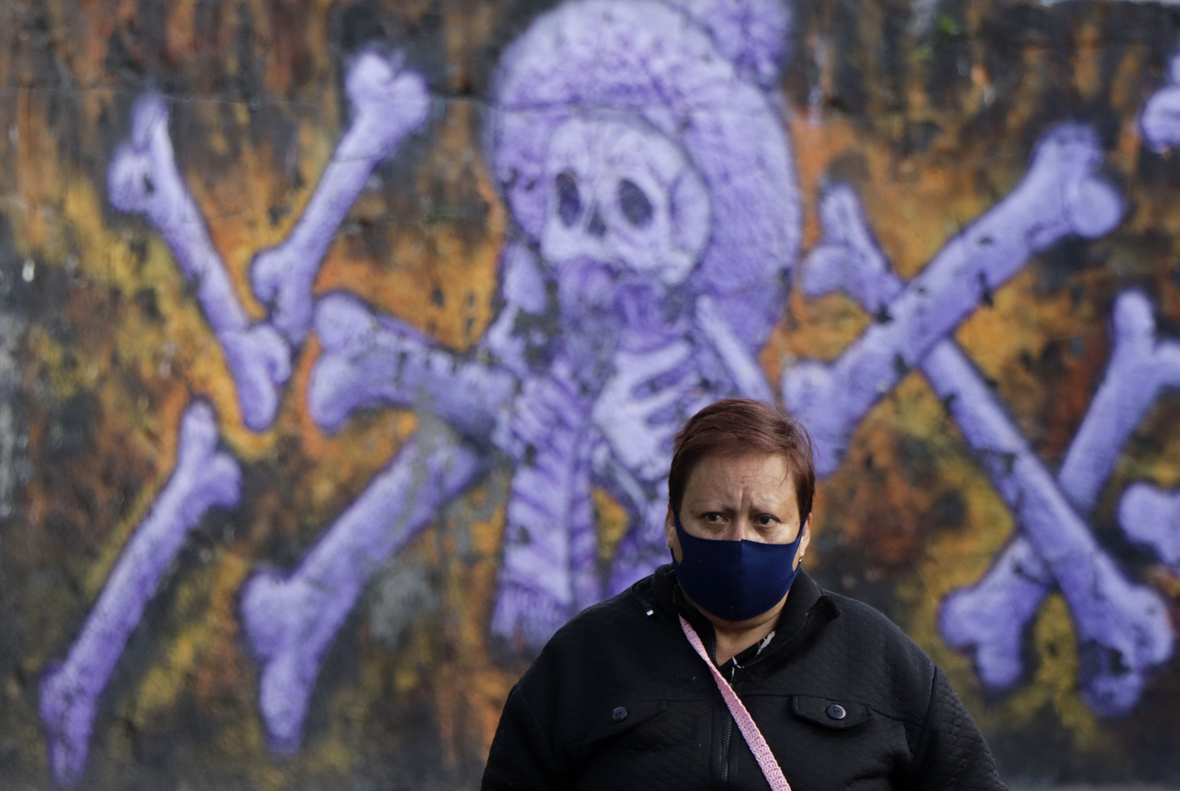 12/06/2020 12 June 2020, Mexico, Mexico City: A woman wearing a black face mask stands at the entrance of the crematorium "San Nicolas Tolentino" in front of a mural amid the Coronavirus pandemic. Despite the ongoing corona pandemic, Mexico's President Lopez Obrador wants to return to normality as quickly as possible. Photo: Gerardo Vieyra/dpa POLITICA INTERNACIONAL Gerardo Vieyra/dpa 
