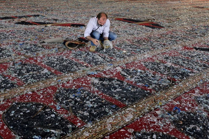 Un hombre revisa los vidrios rotos sobre la alfombra de una mezquita dañada por la explosión en Beirut. Agosto 5, 2020. REUTERS/Aziz Taher
