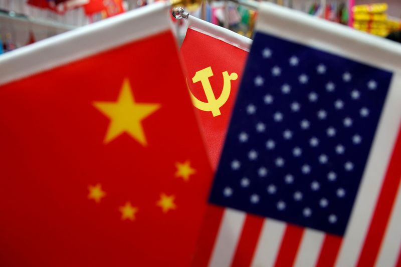 Las banderas de China y EEUU, de fondo el logo del partido comunista 