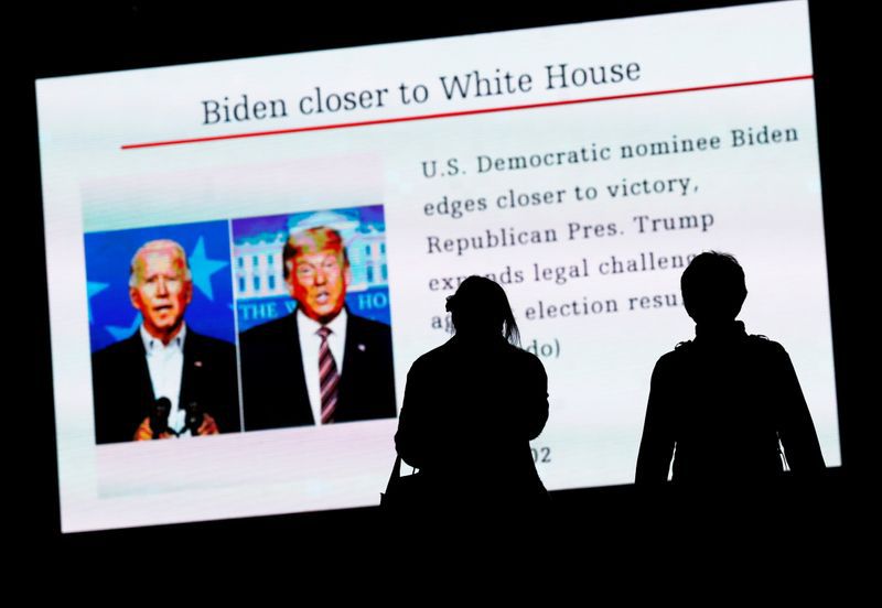 Transeúntes miran pantalla que muestra informes sobre las elecciones presidenciales de Estados Unidos de 2020, Tokio, Japón, 6 noviembre 2020.
REUTERS/Issei Kato