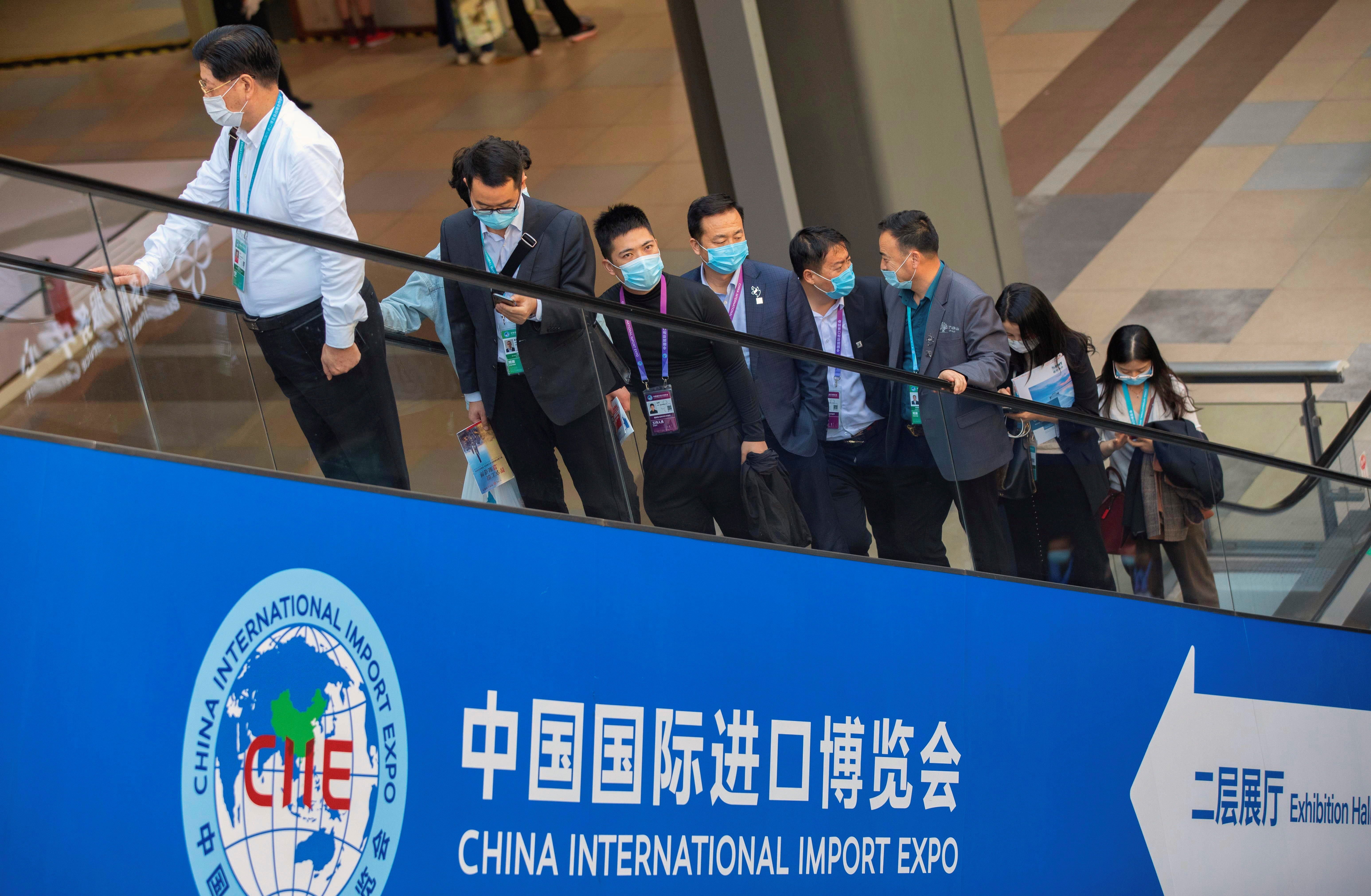Numerosos visitantes montan en una escalera mecánica en la 3ª Exposición Internacional de Importación de China en Shanghai, China, EFE/EPA/ALEX PLAVEVSKI 