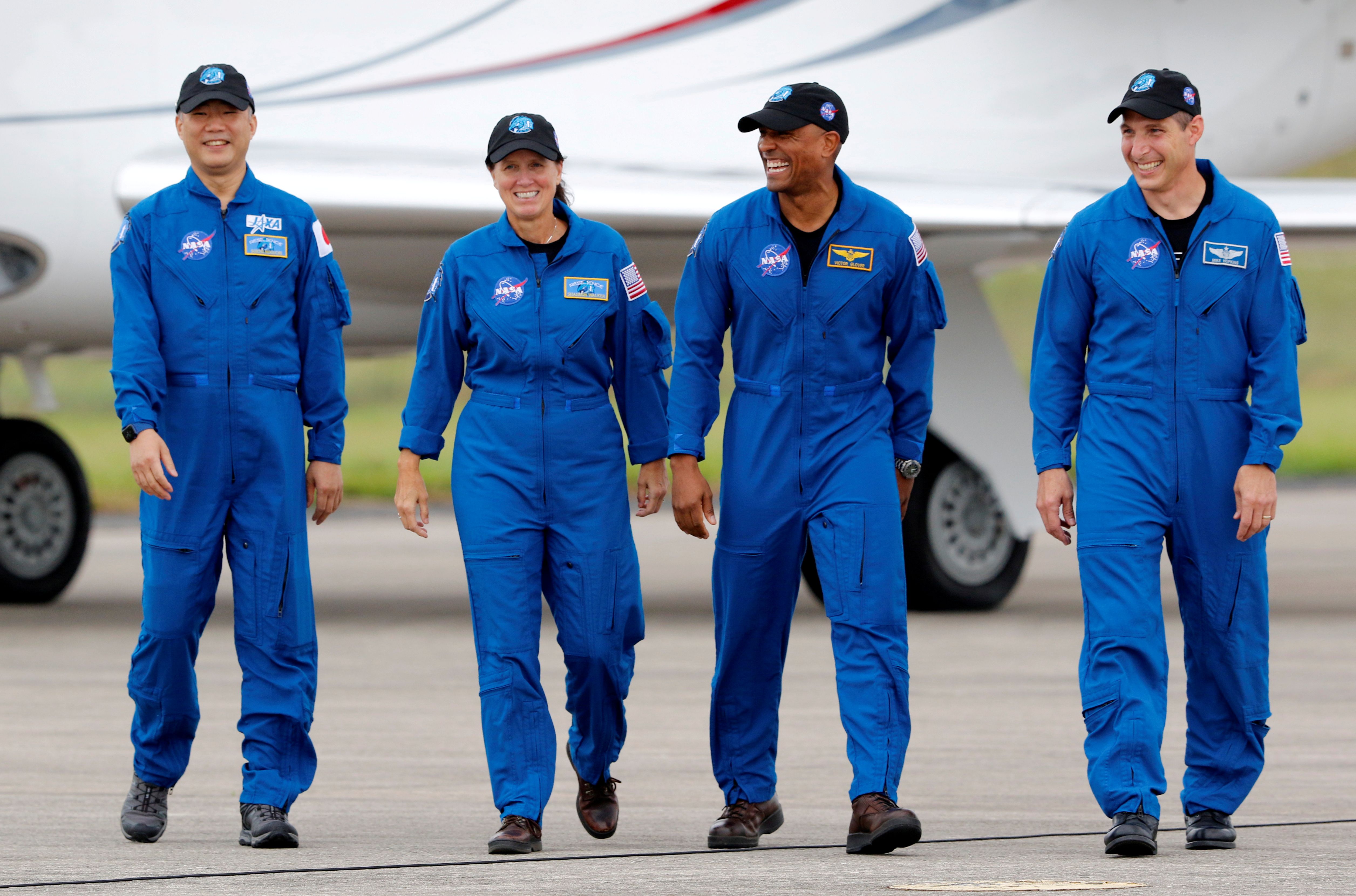 Los astronautas de la NASA Shannon Walker, Victor Glover, Mike Hopkins, y el astronauta de la JAXA (Agencia de Exploración Aeroespacial de Japón) Soichi Noguchi, que forman la Tripulación 1, caminan en el Centro Espacial Kennedy antes del lanzamiento de la primera misión comercial de la tripulación de la NASA/SpaceX en Cabo Cañaveral, Florida, EE.UU