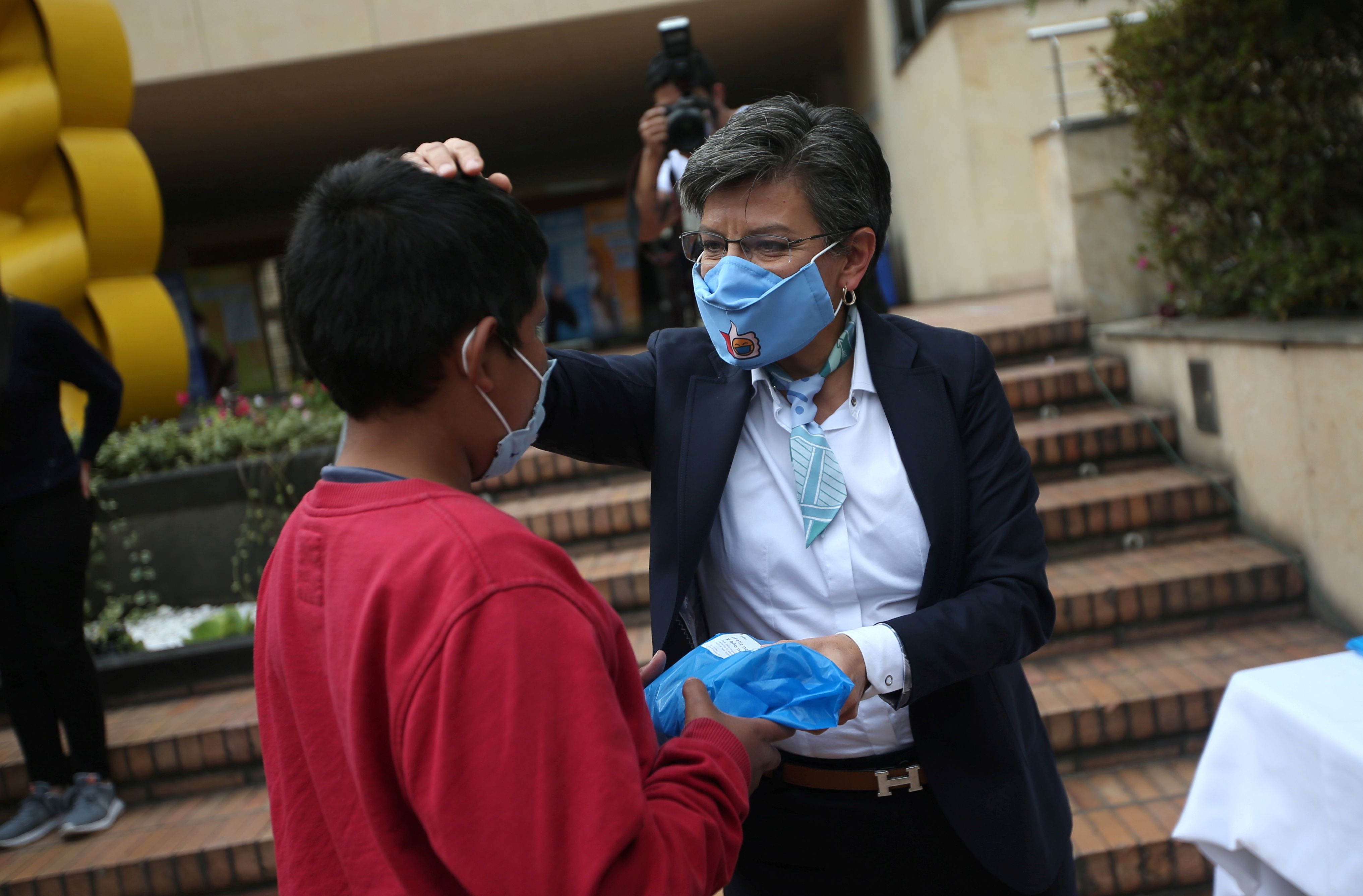 The mayor of Bogota Claudia Lopez wearing a face mask gives a gift to a Venezuelan migrant child during a Christmas event of the Bogota mayor's office, in Bogota, Colombia December 17, 2020. REUTERS/Luisa Gonzalez