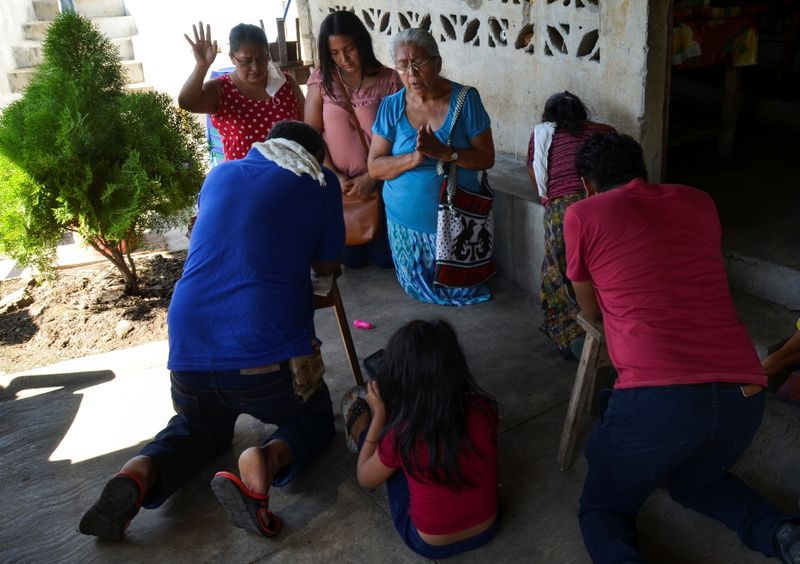 FOTO DE ARCHIVO. Amigos rezan en la casa de Gerardo Zacarías y su esposa María Victoria Orozco, quienes temen que su hija Paola Damaris esté entre los 19 cuerpos encontrados con disparos y quemados en una zona remota del norte de México, en Catarina, Guatemala 29 de enero de 2021. REUTERS/José Torres