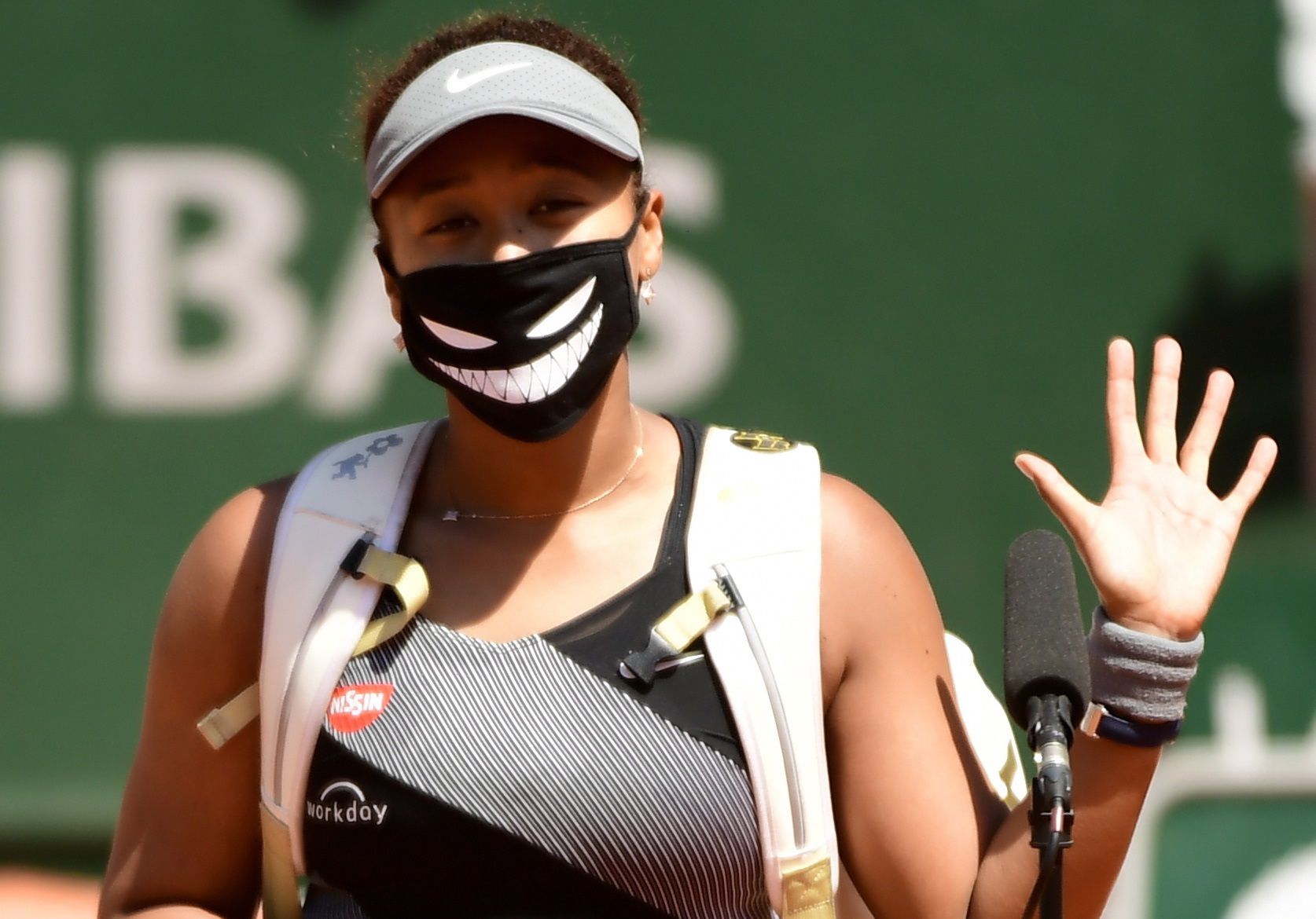 Naomi Osaka, con un tapabocas que esconde parte de su rostro y le dibuja una sonrisa, en el partido que ganó en Roland Garros antes de retirarse (Foto: EFE)