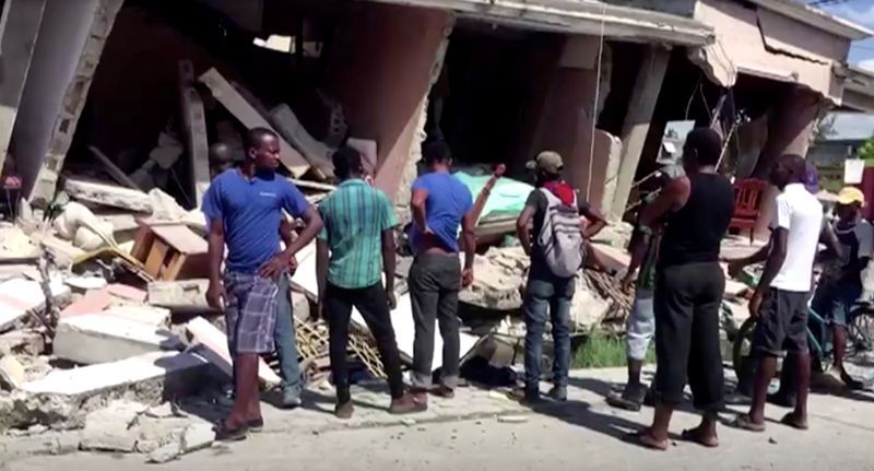 Personas observan una edificación que colapsó tras un terremoto magnitud 7,2 que sacudió Les Cayes, en Haití, en esta imagen tomada de un video obtenido por Reuters el 14 de agosto de 2021. REUTERS TV vía REUTERS. ESTA IMAGEN FUE CEDIDA POR UN TERCERO. CRÉDITO OBLIGATORIO