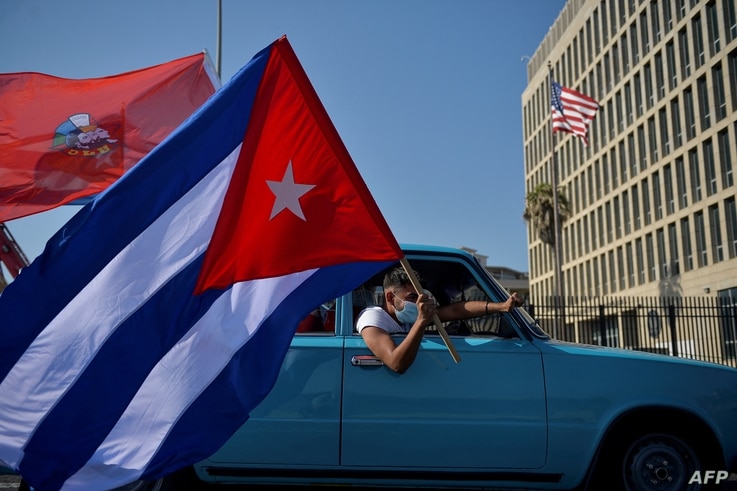 Cubans drive past the U.S. embassy during a rally calling for the end of the U.S. blockade against Cuba, in Havana, March 28, 2021