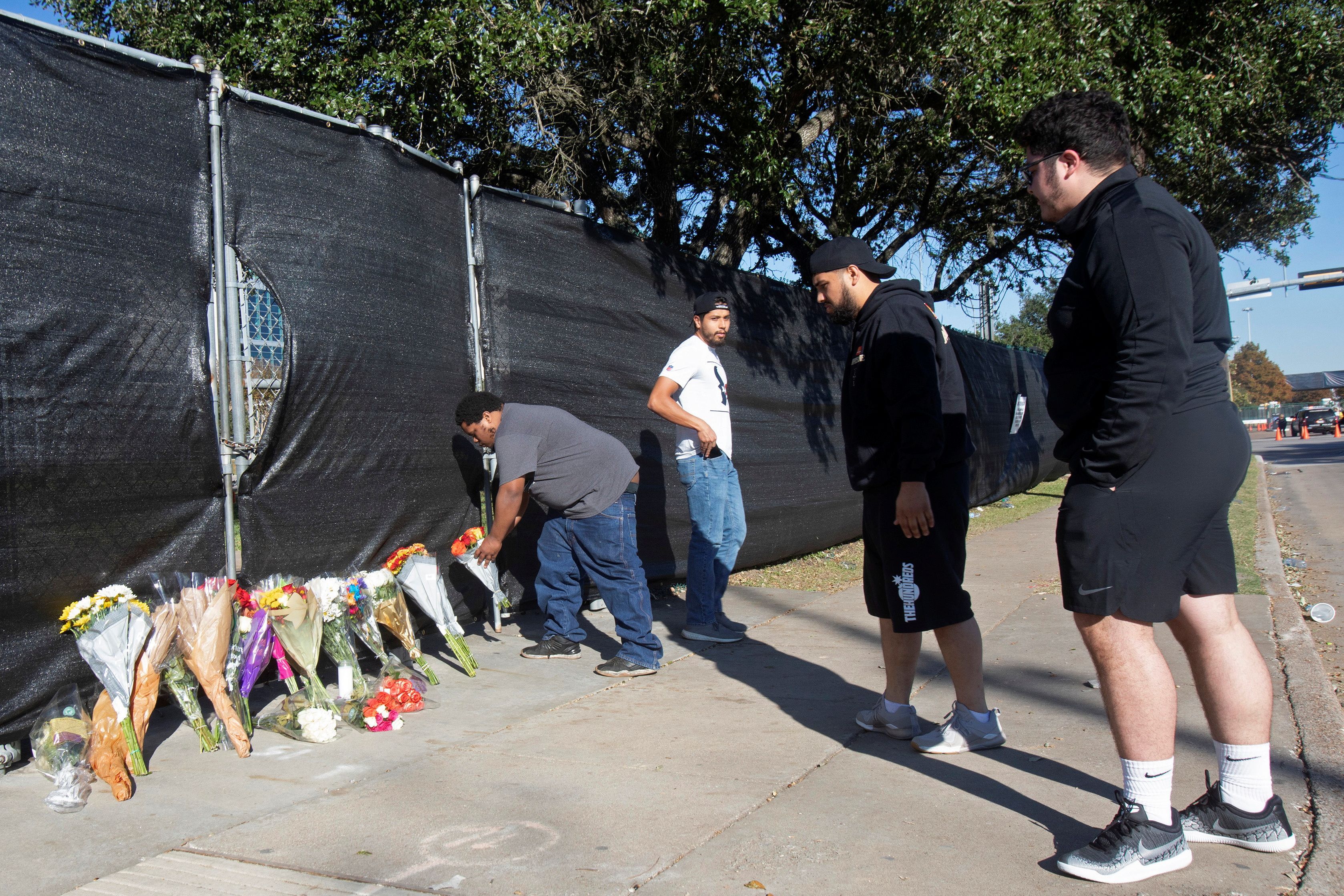 Matthew Shelton, Diego Rivera, Anthony Perez and Juan Carillo place flowers on a gate to NRG Park, after a deadly crush of fans during a performance the night before at the Astroworld Festival by rapper Travis Scott in Houston, Texas, U.S. November 6, 2021. REUTERS/Daniel Kramer