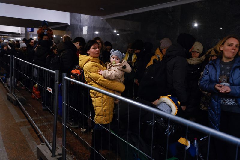 FOTO DE ARCHIVO: Una mujer sostiene un niño mientras personas huyen de la invasión de Rusia a Ucrania en la estación de trenes en Lviv, Ucrania, 21 de marzo del 2022. REUTERS/Zohra Bensemra/Foto de archivo