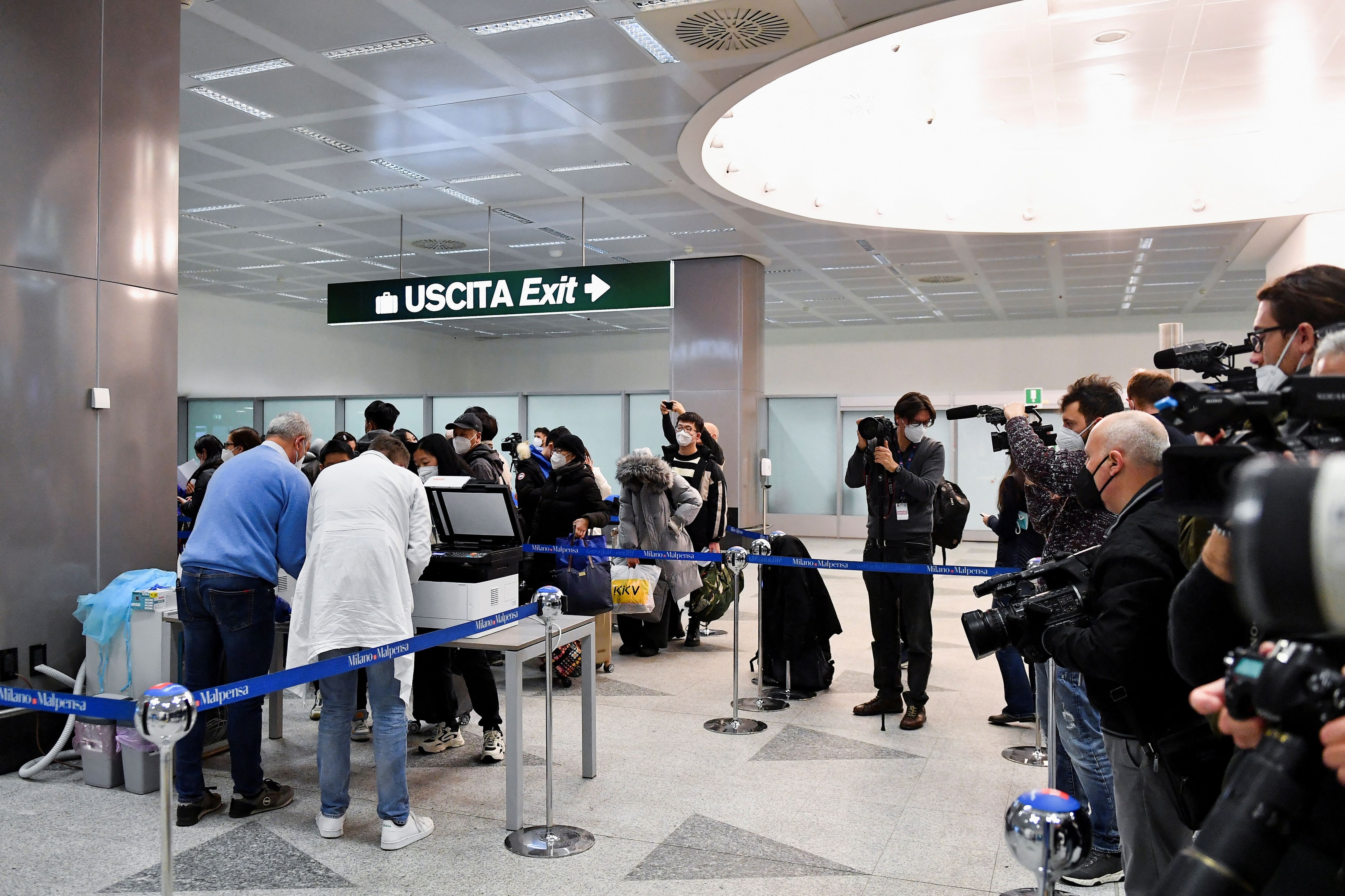 Los pasajeros hacen cola para registrarse antes de someterse a las pruebas de detección de la enfermedad por coronavirus (COVID-19), después de que Italia haya ordenado la realización de frotis con antígeno COVID-19 y la secuenciación del virus a todos los viajeros procedentes de China, donde están aumentando los casos, en el aeropuerto de Malpensa en Milán, Italia, 29 de diciembre de 2022. REUTERS/Jennifer Lorenzini
