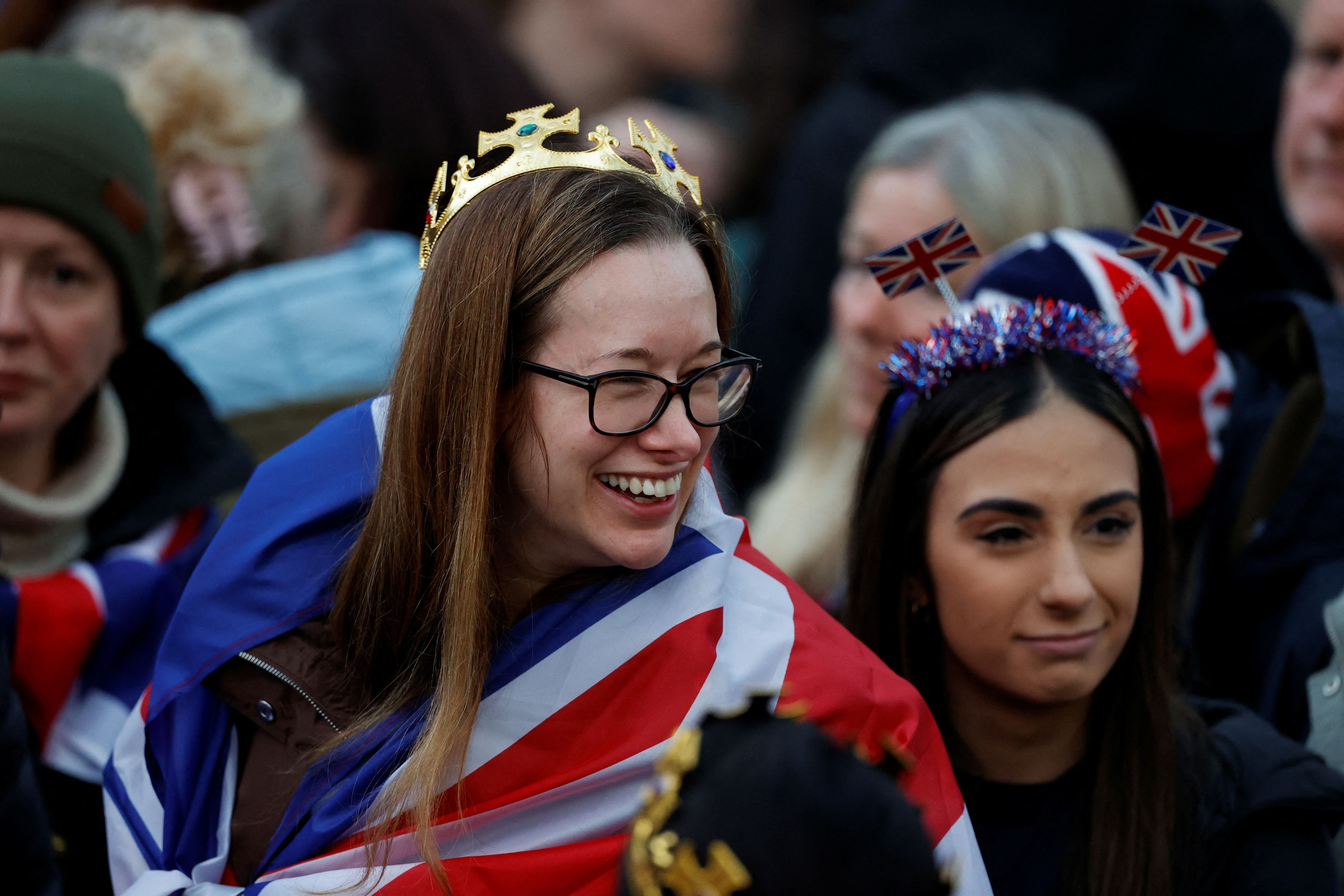 La gente espera para ver la procesión del rey Carlos III a la Abadía de Westminster, para su coronación. (REUTERS)