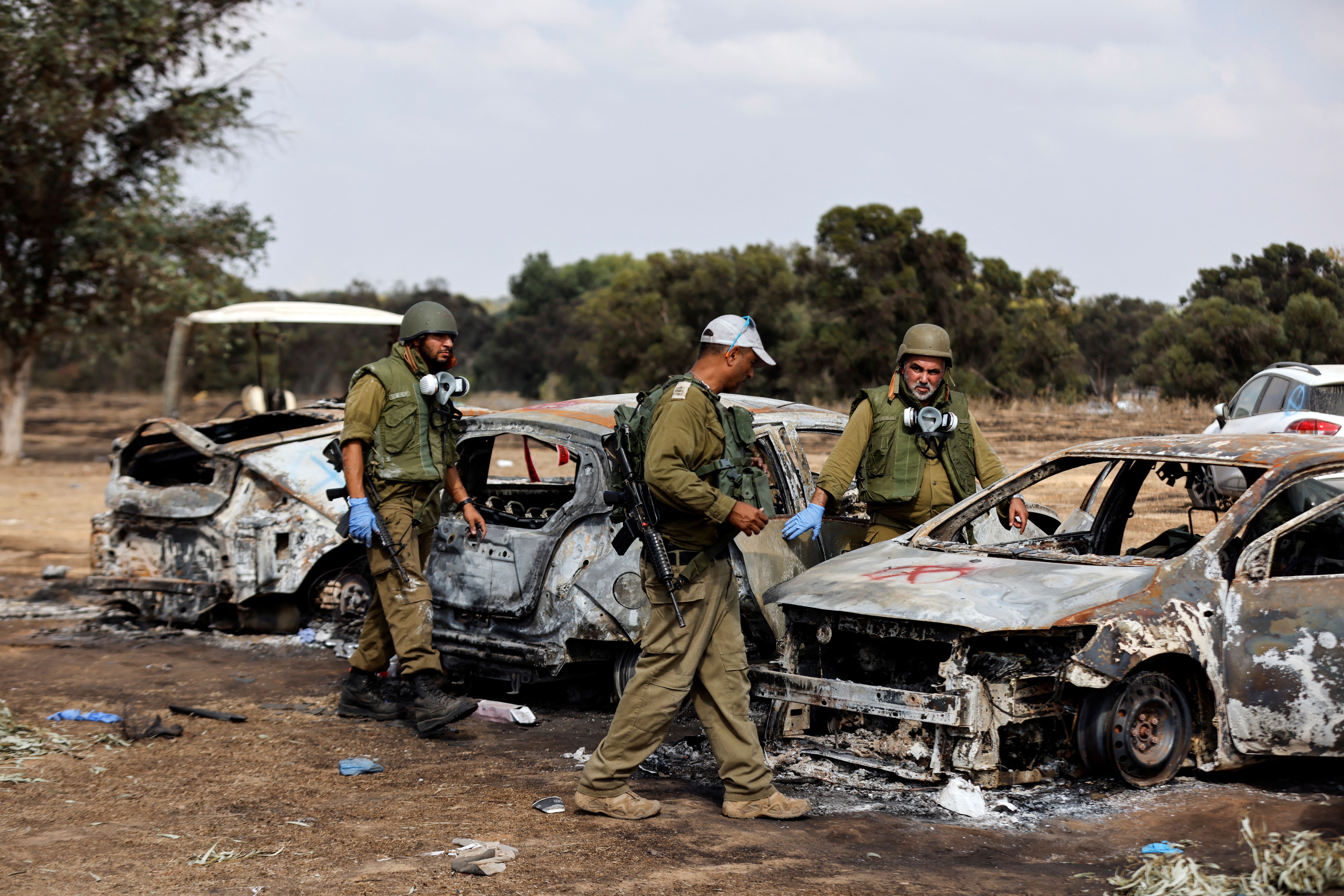 Soldados israelíes inspeccionan los automóviles quemados de los asistentes al festival en el lugar de un ataque al Festival Nova por parte de hombres armados de Hamas desde Gaza, cerca de la frontera de Israel con la Franja de Gaza, el 13 de octubre de 2023 - crédito REUTERS/Amir Cohen.