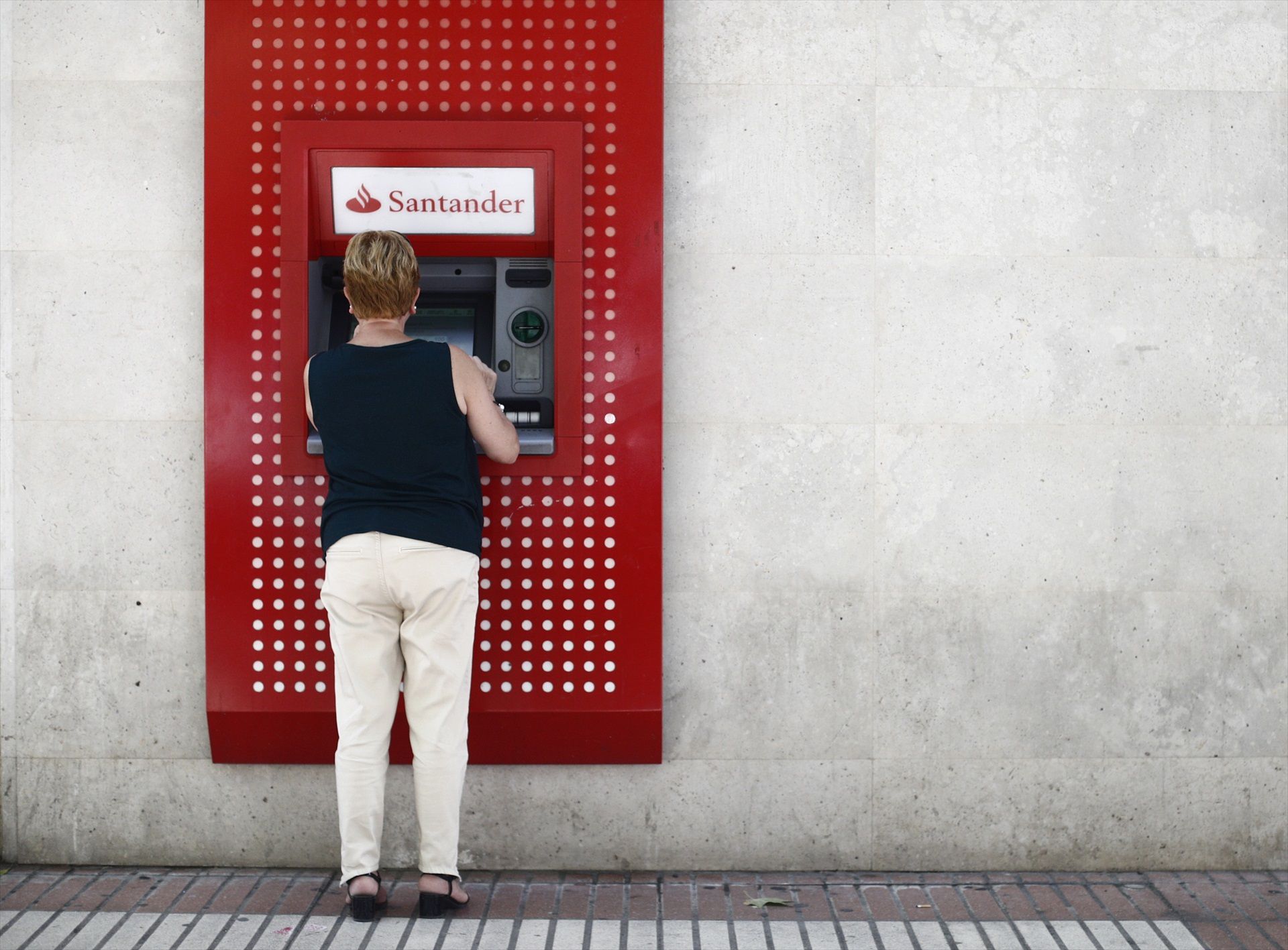 Una mujer saca dinero en un cajero del Banco Santander en Madrid (Europa Press)