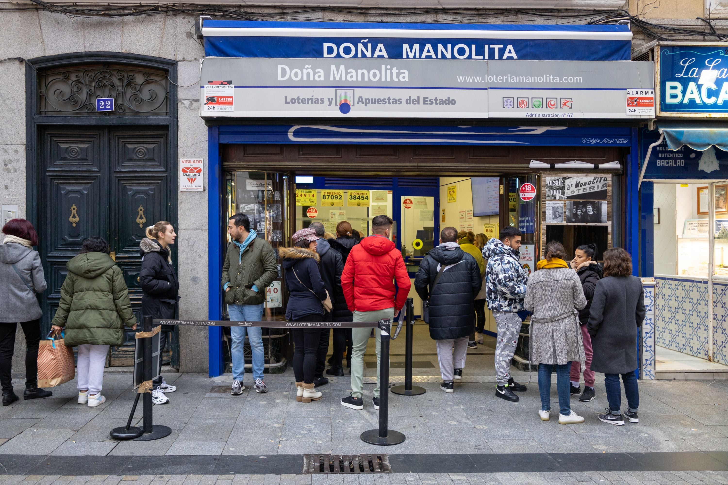 La gente hace cola durante más de seis horas para comprar un décimo de la Lotería de Navidad. (Helena Margarit Cortadellas)