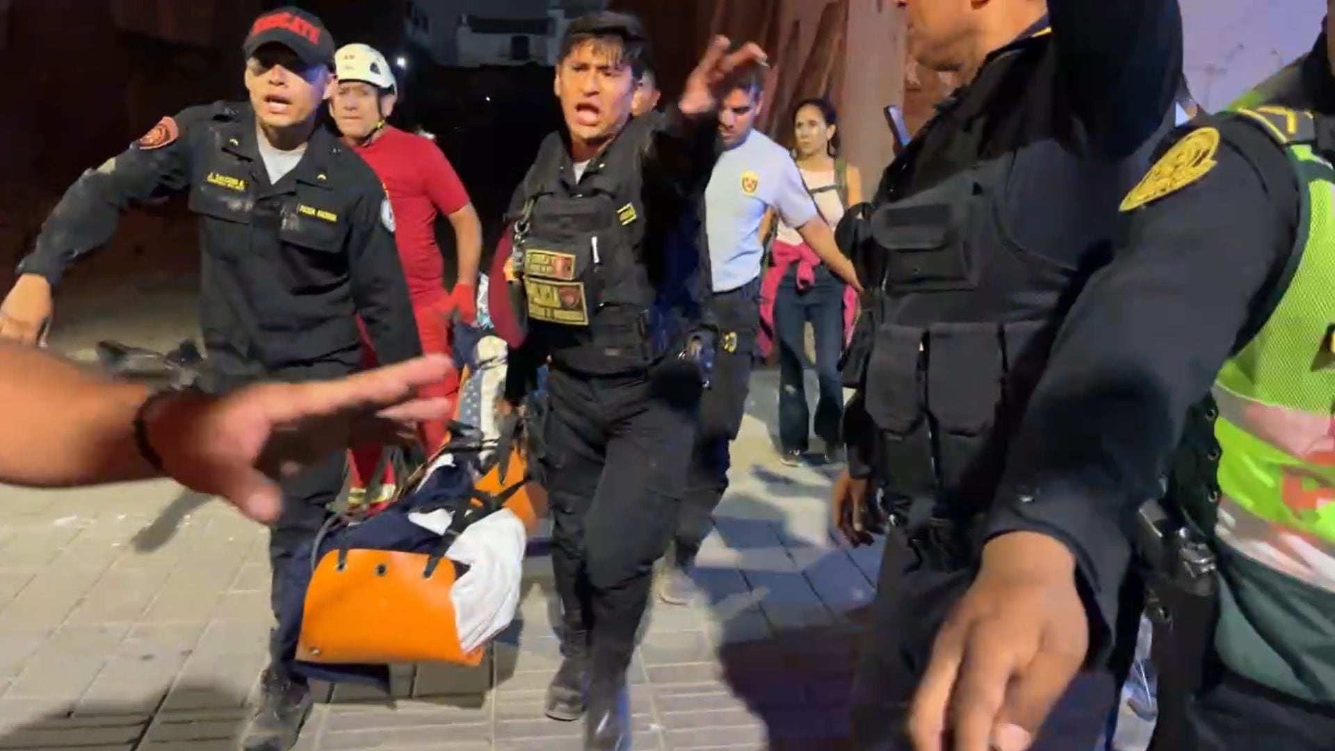 Policías y bomberos cargan sobre una camilla a una de las personas atrapadas, luego del derrumbe en el inmueble del Centro Histórico de Trujillo.
