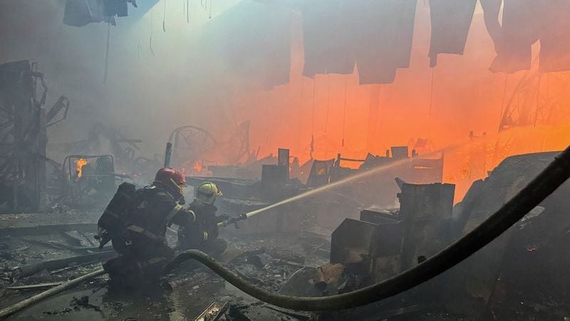 Los bomberos trabajan en un centro comercial de artículos para el hogar blanco de un ataque aéreo ruso, en Járkov
