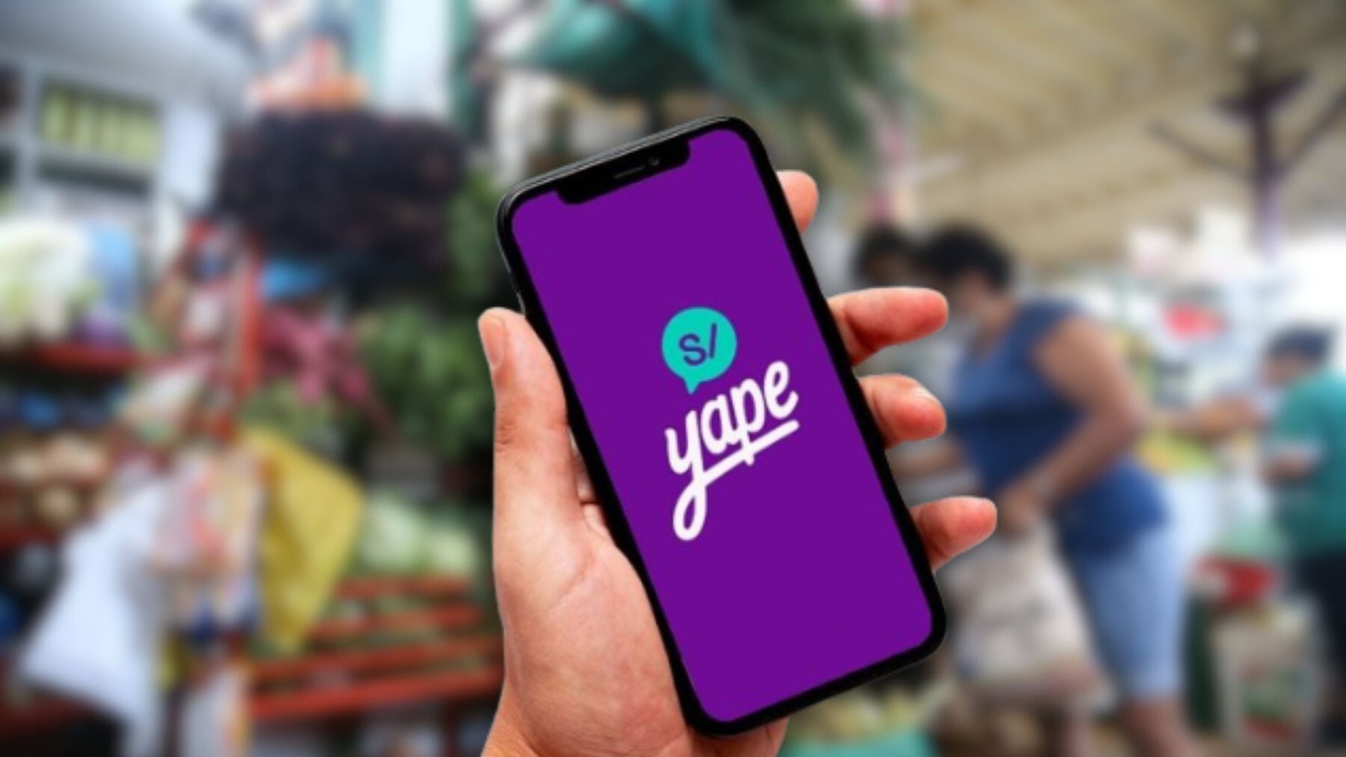 Mano con celular con Yape en el fondo de mercado peruano