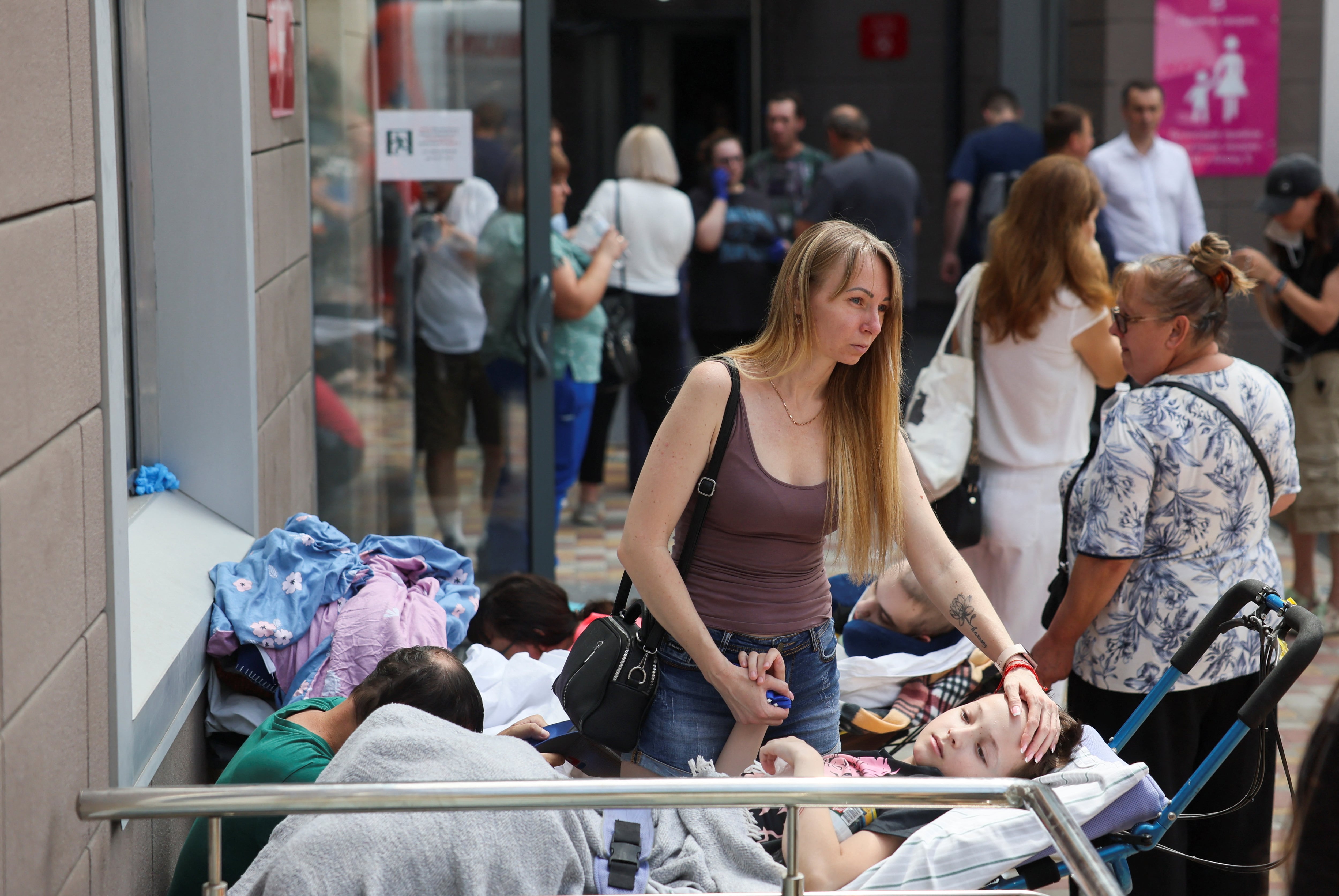 Una mujer con un niño tras el ataque ruso sobre el hospital infantil (REUTERS/Gleb Garanich)