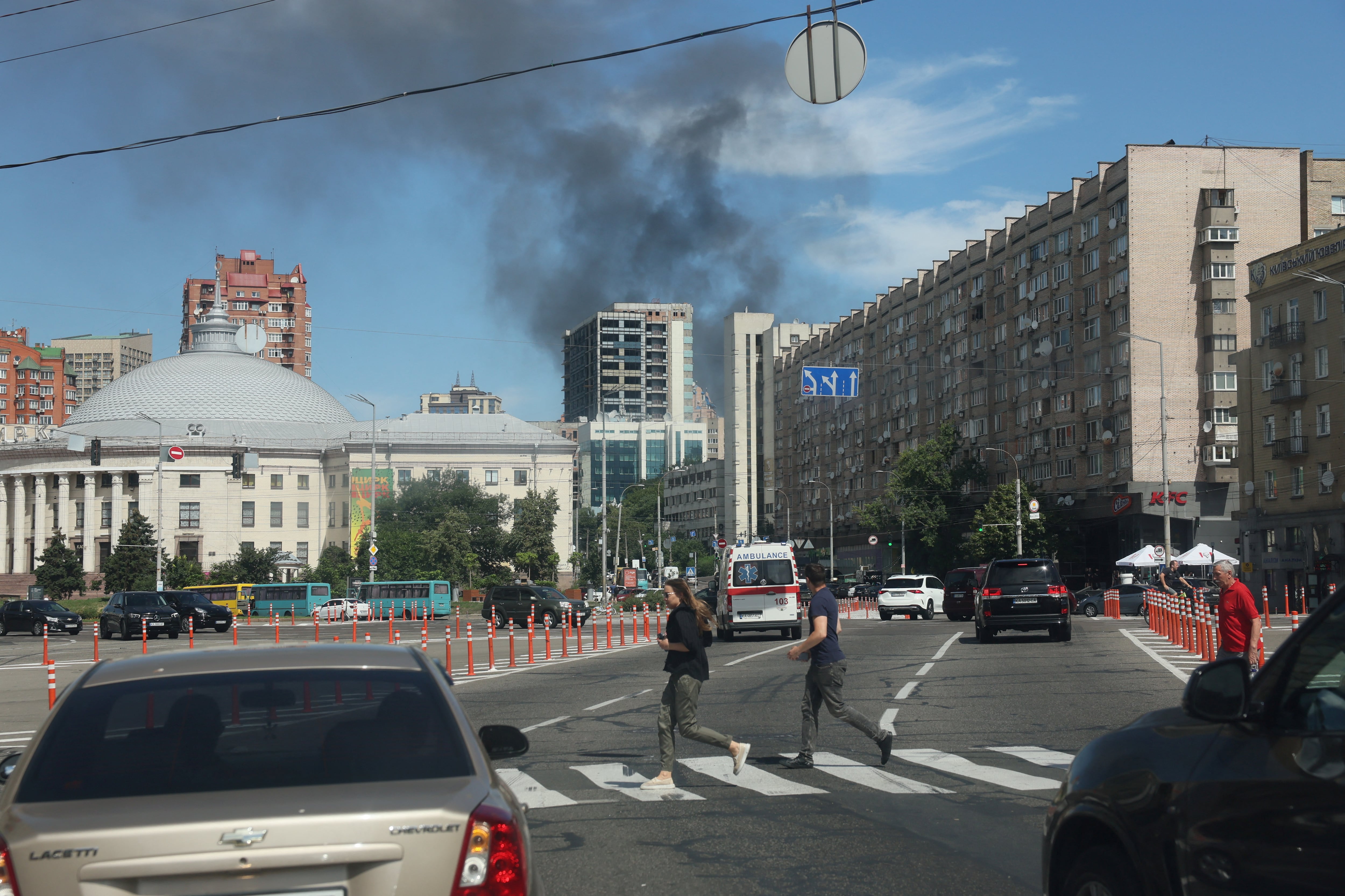 El humo se eleva mientras la gente corre, tras los ataques con misiles rusos en Kiev (REUTERS/Gleb Garanich)